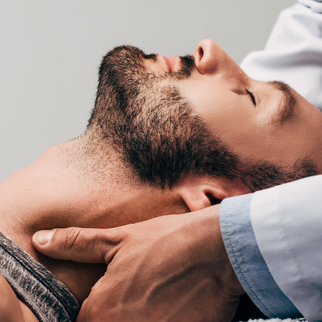 panoramic shot of chiropractor massaging neck of man on grey