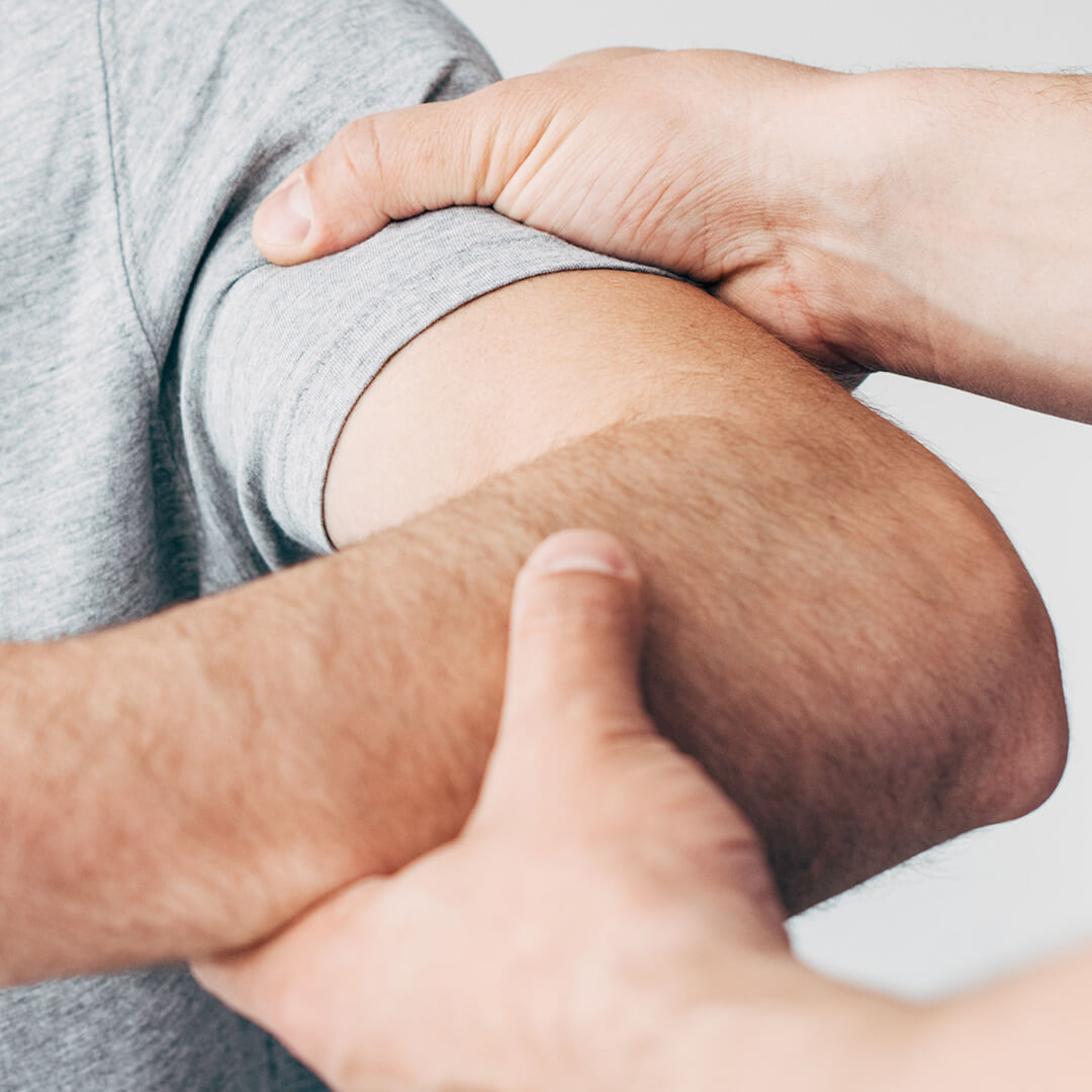 panoramic shot of chiropractor massaging arm of patient in hospital